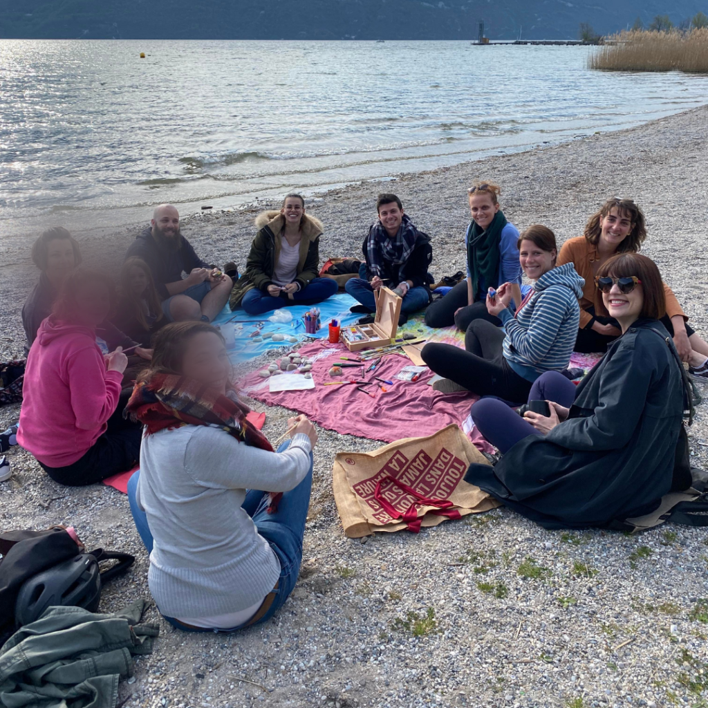 Groupe de personne souriant faisant de la peinture sur galets au bord du lac d'Aix-les-Bains